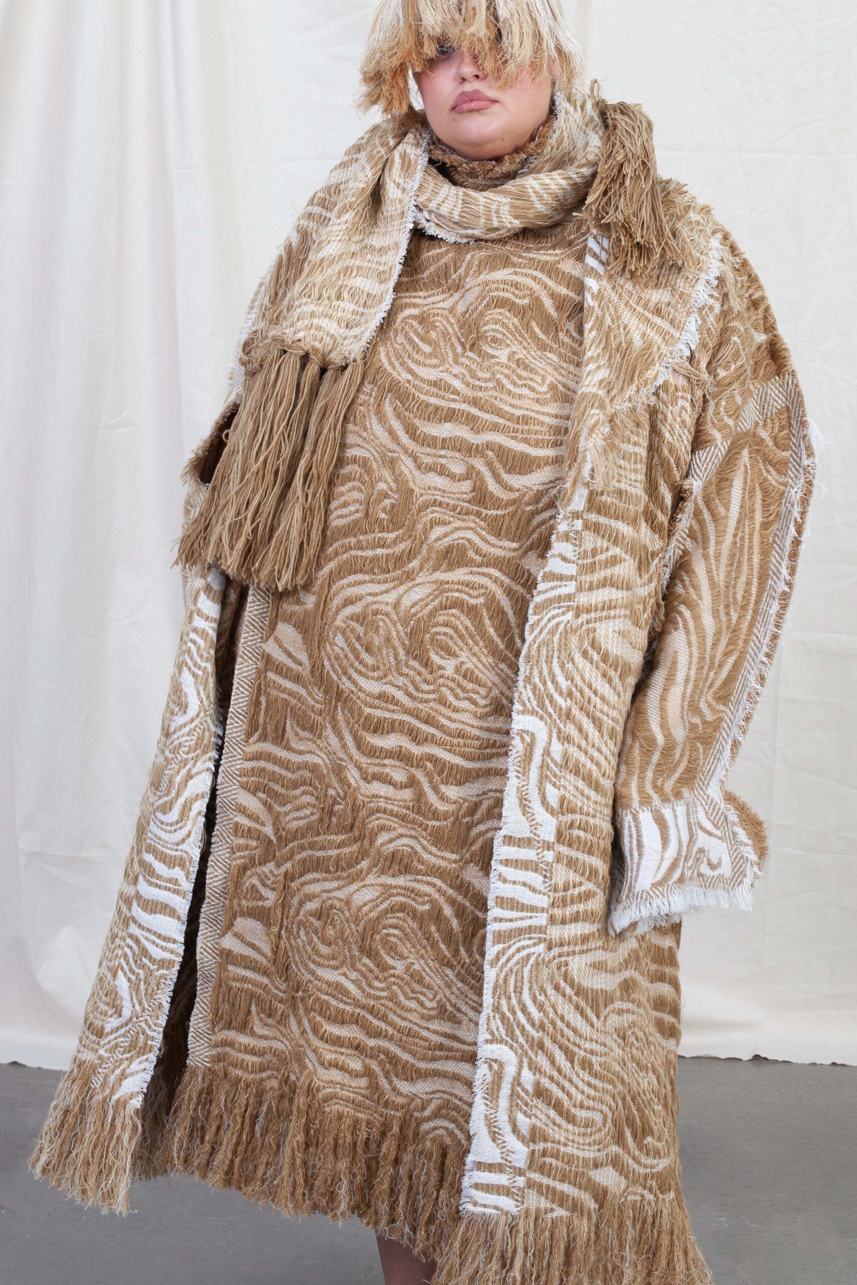Model iført frakke og kjole designet af Kelly Konings