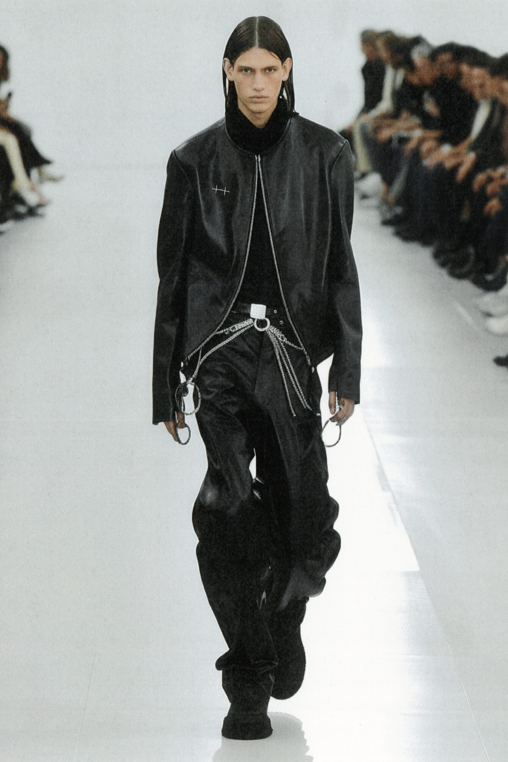 Model iført Heliot Emil læderjakke og bukser med kæde under Paris Fashion Week SS24 brugt AI