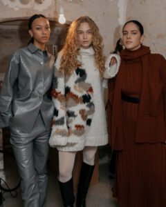 Billede af tre modeller backstage ved Aeron AW24-modeshow under Copenhagen Fashion Week.